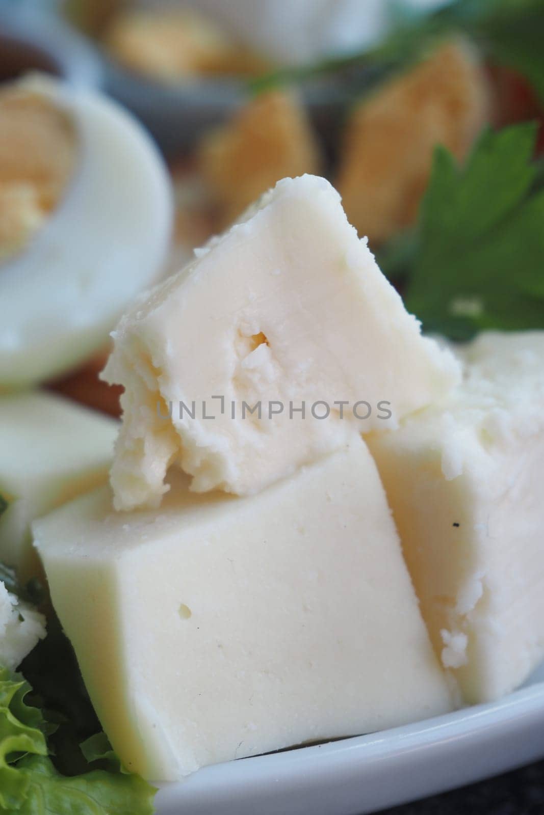 Delightful soft cheese cubes accompanied by a selection of fresh greens and garnishes