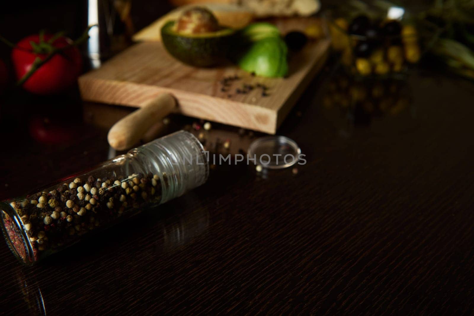 A rustic kitchen scene featuring a pepper shaker, fresh avocado, and spices. Warm, inviting atmosphere perfect for culinary inspiration and gourmet cooking ideas.