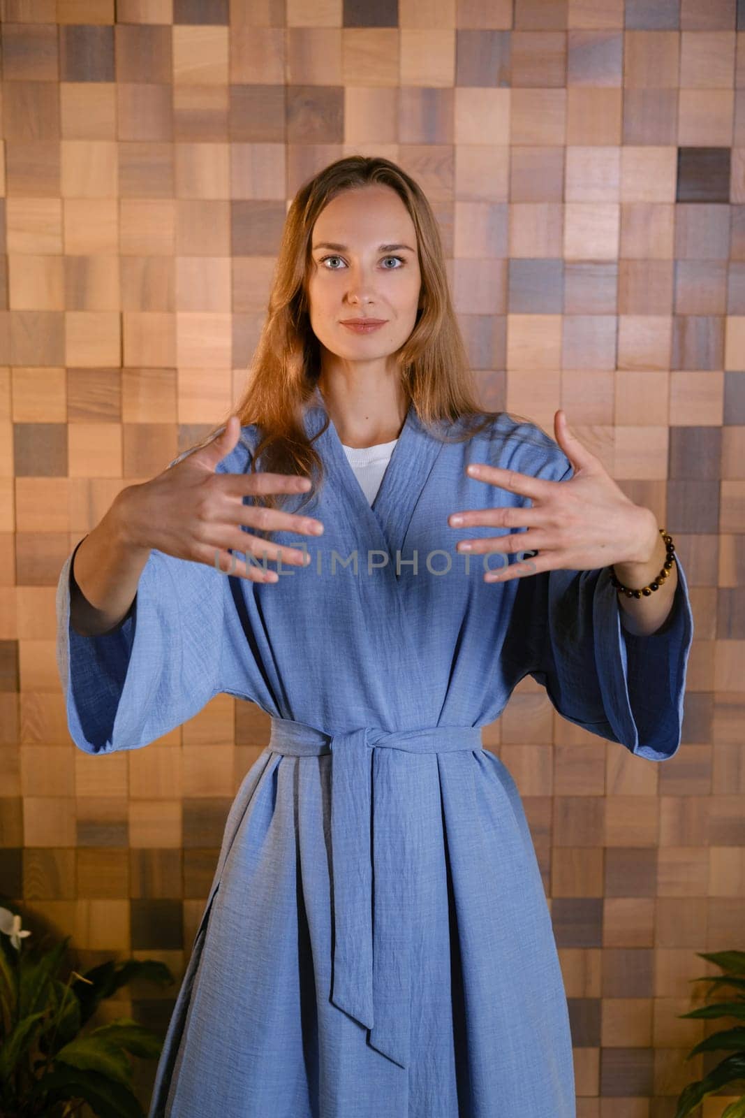 Girl in blue kimano practicing kundalini or qigong yoga in fitness gym . Spiritual energy, life force located at the base of the spine.