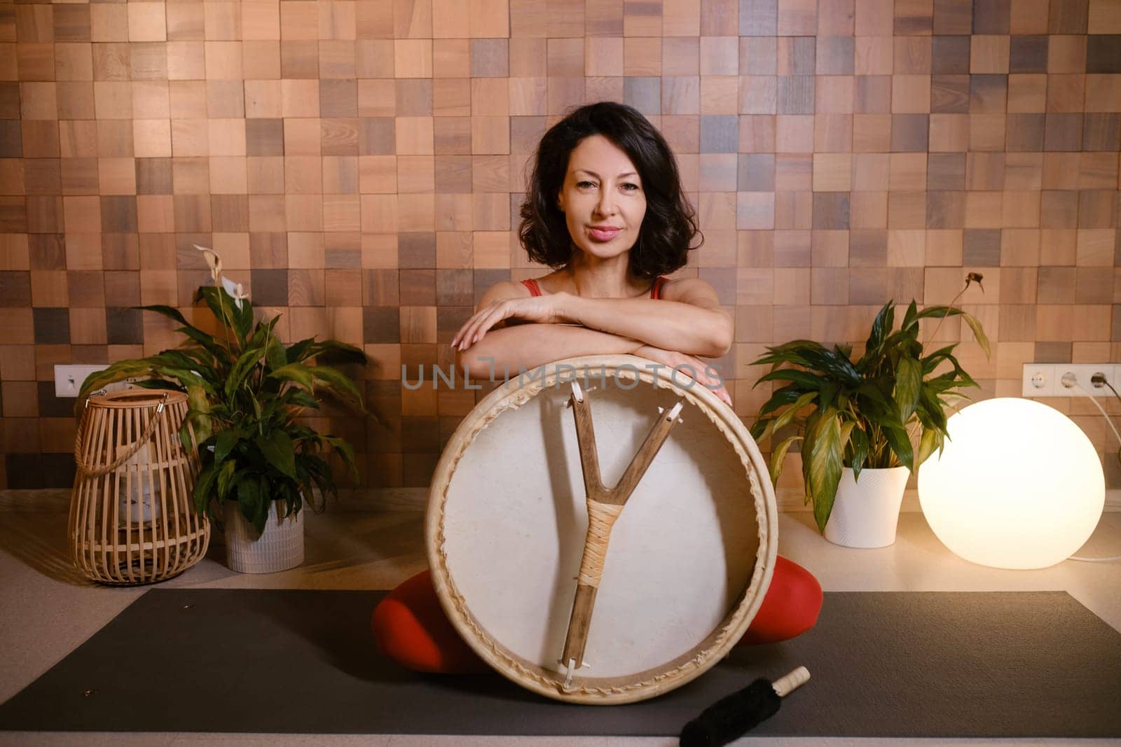 Portrait of an athletic woman with a tambourine in the gym. Kalimeditation class.