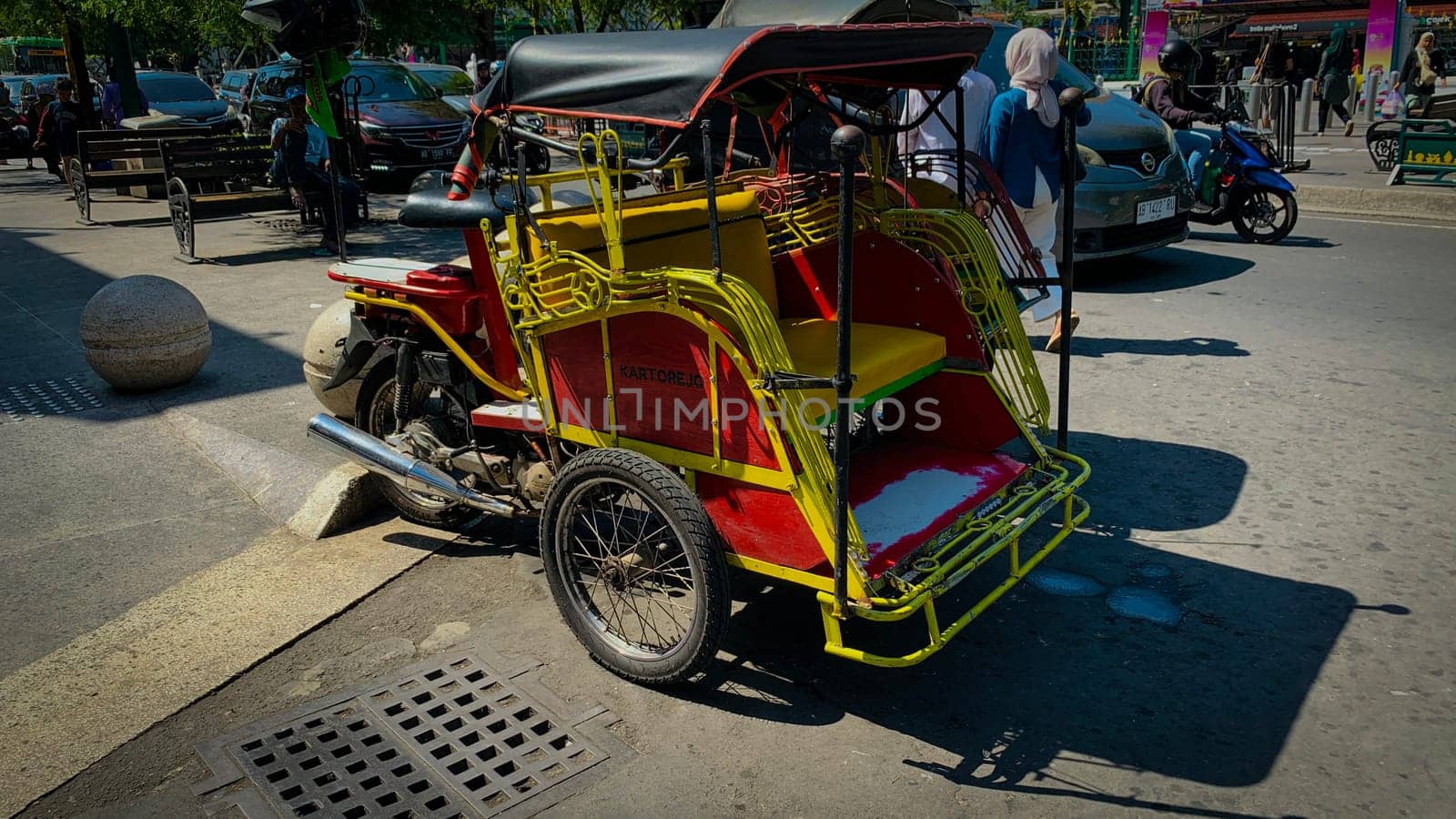 pedicab or rickshaw or locals calls it becak with a canopy is parked on a sunny street, reflecting a vibrant urban scene. The vehicle features a padded seat and unique design