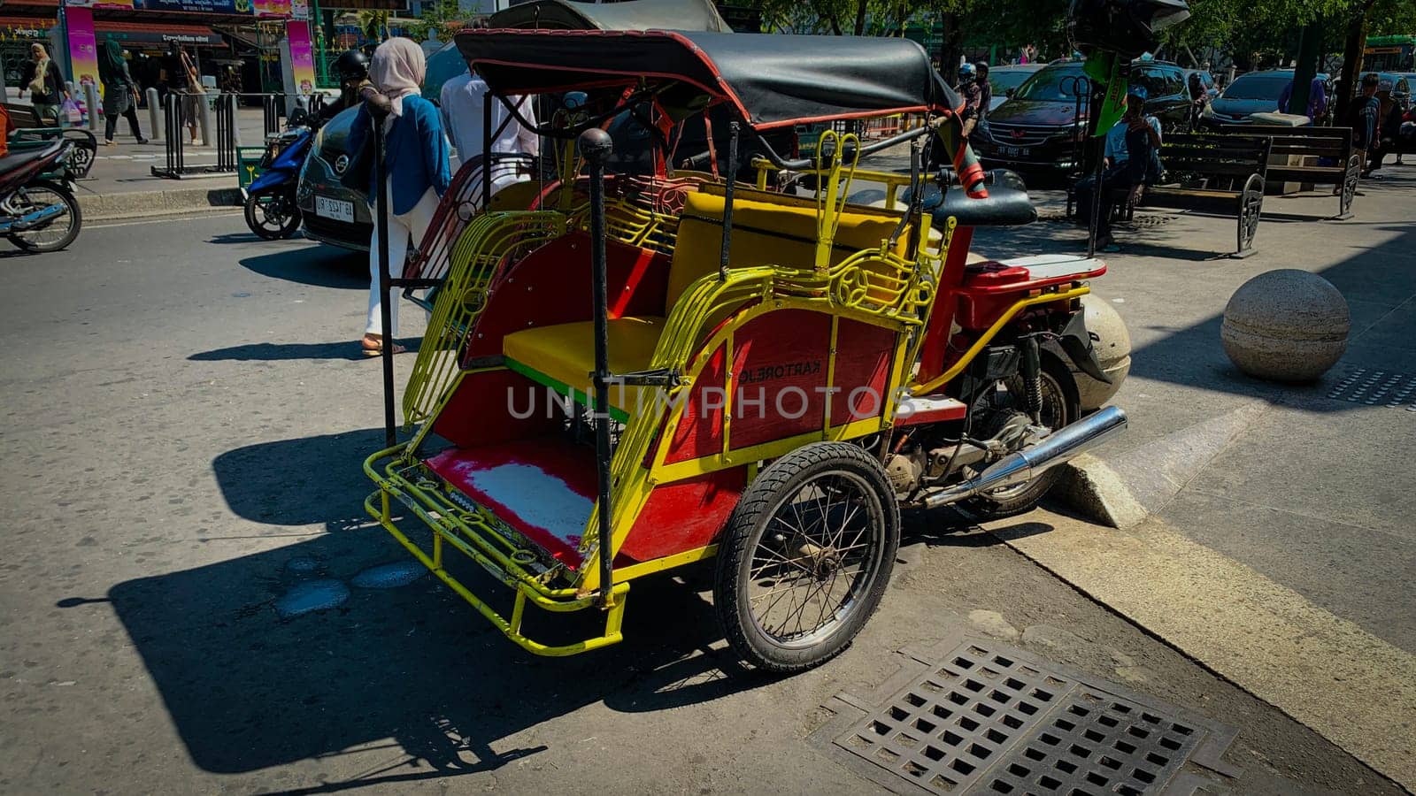 pedicab or rickshaw or locals calls it becak with a canopy is parked on a sunny street, reflecting a vibrant urban scene. The vehicle features a padded seat and unique design