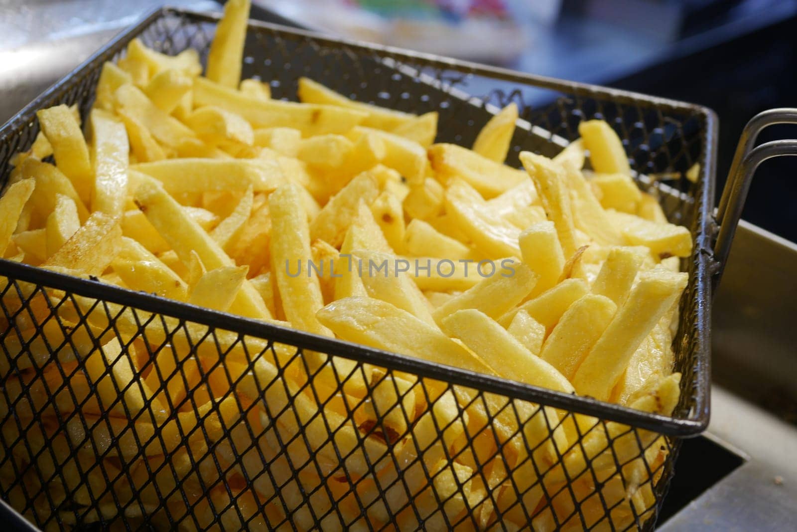 Enjoy a serving of crispy golden French fries that are beautifully presented in a metal basket