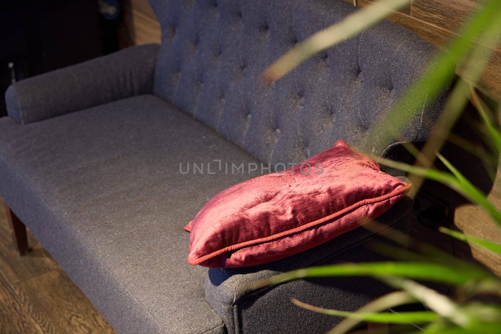 A stylish gray sofa adorned with cozy burgundy pillows, perfect for elevating any living spaces ambiance