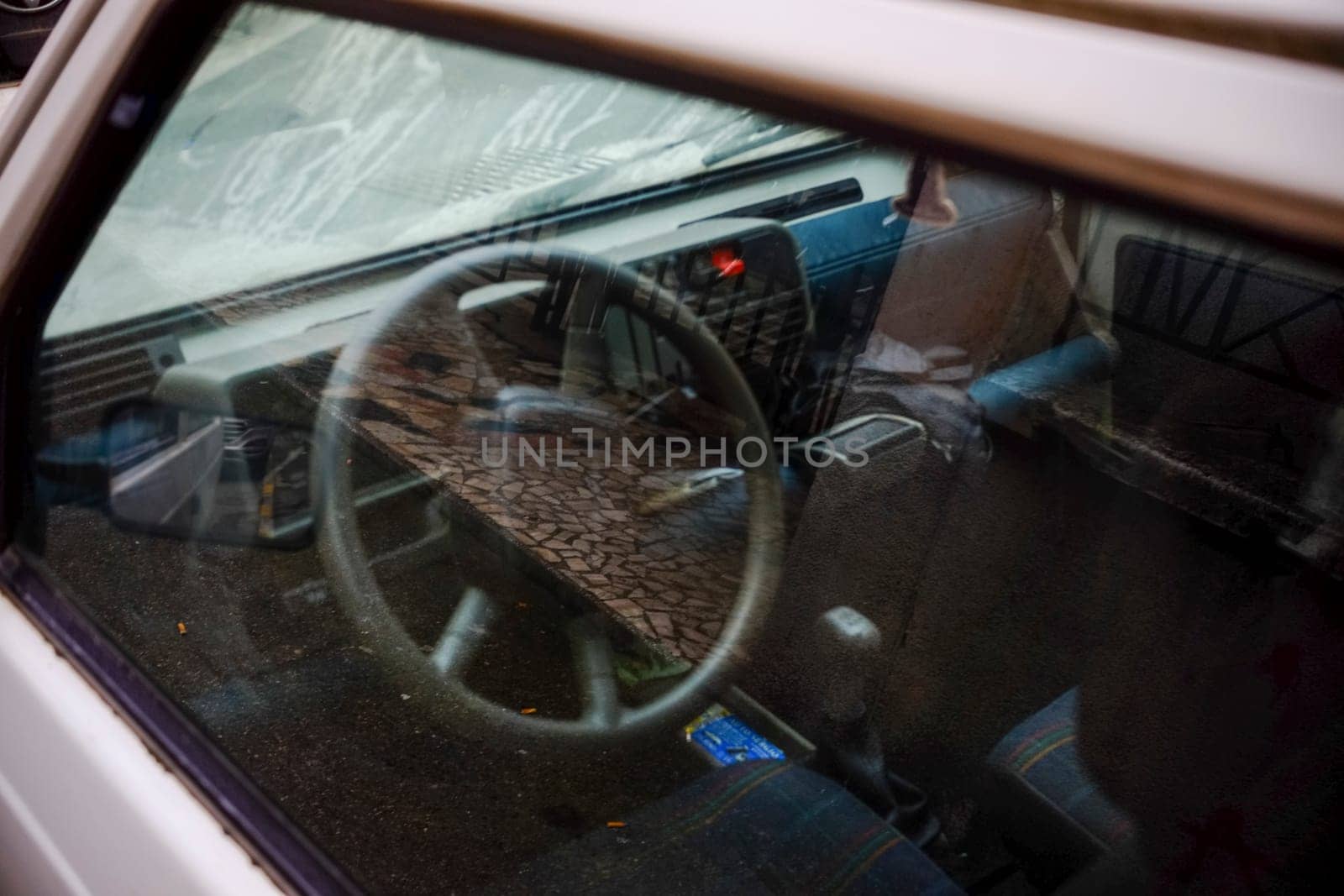 Cremona, Itally - October 6th 2024 Viewing the interior of a parked 1980s white fiat panda 4x4 sisley through the window, with a focus on the steering wheel and dashboard