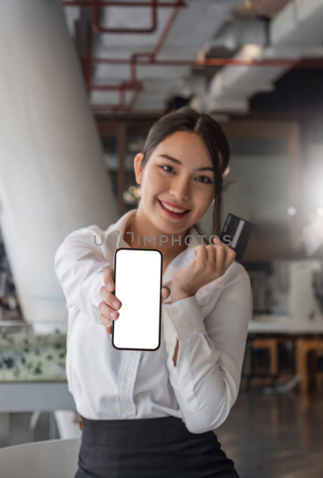 beautiful Asian woman holding smartphone mockup of blank screen and show credit card.