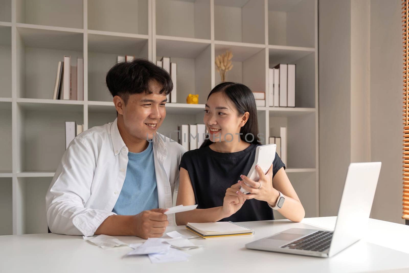 Asian couple hand calculate budget or expense by hold bill at home concept of invest, budget calculation and finance plan.