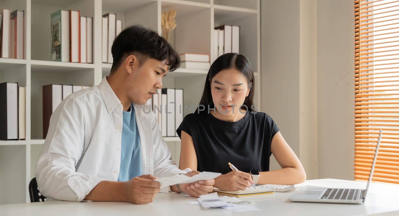 Asian couple hand calculate budget or expense by hold bill at home concept of invest, budget calculation and finance plan by nateemee