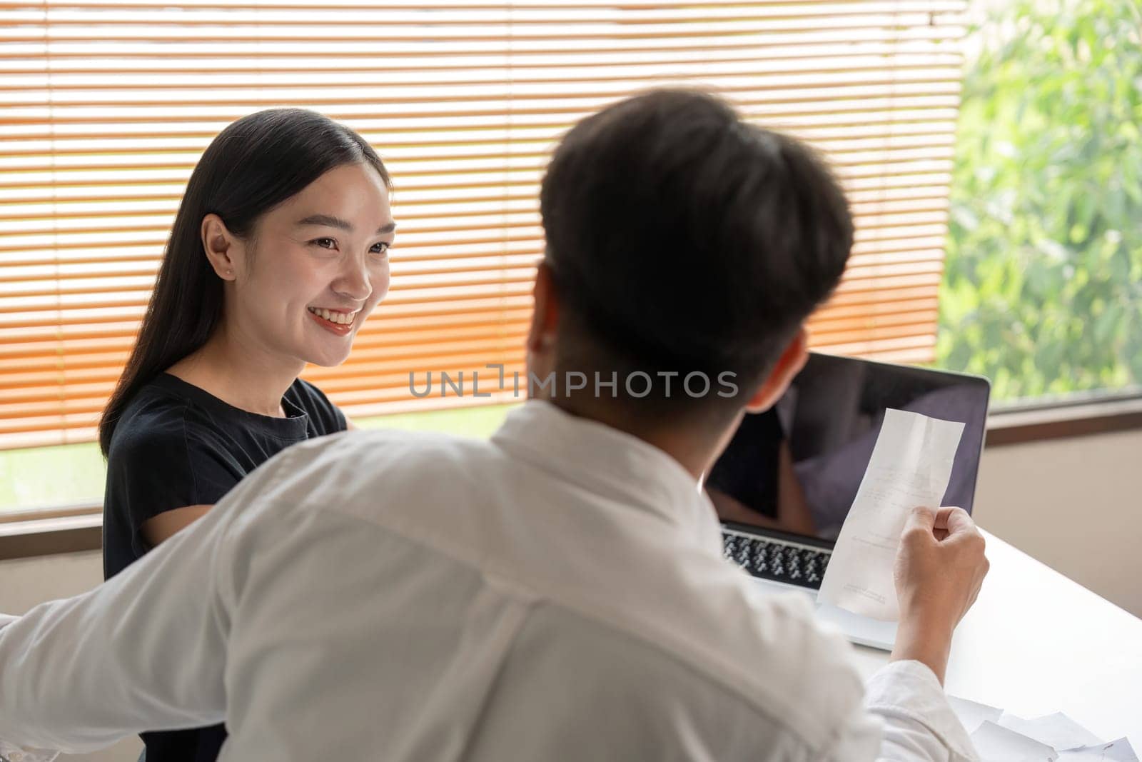 Asian couple hand calculate budget or expense by hold bill at home concept of invest, budget calculation and finance plan by nateemee