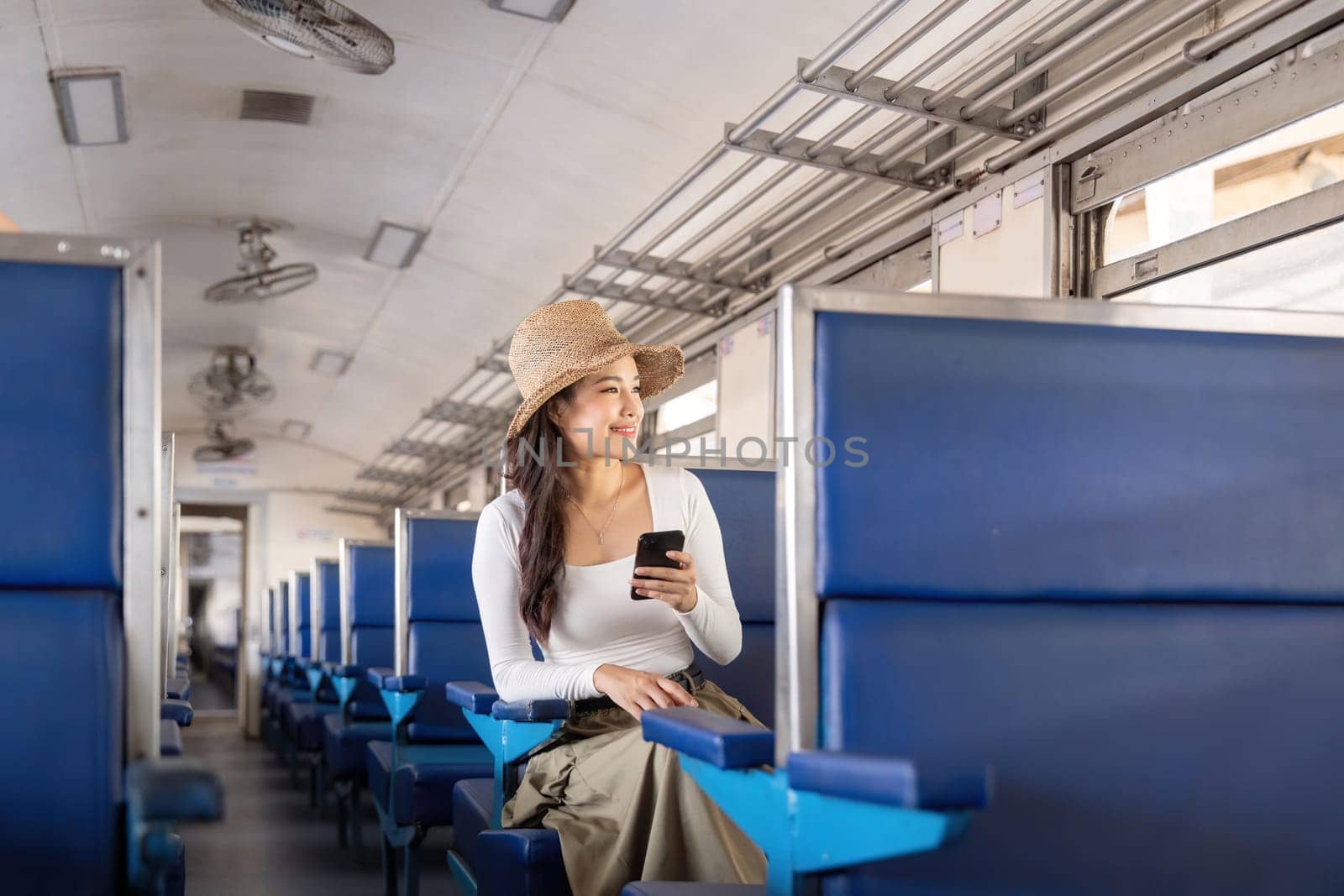 Portrait of woman asian using telephone while traveling by train. Tourism and travel in the summer.