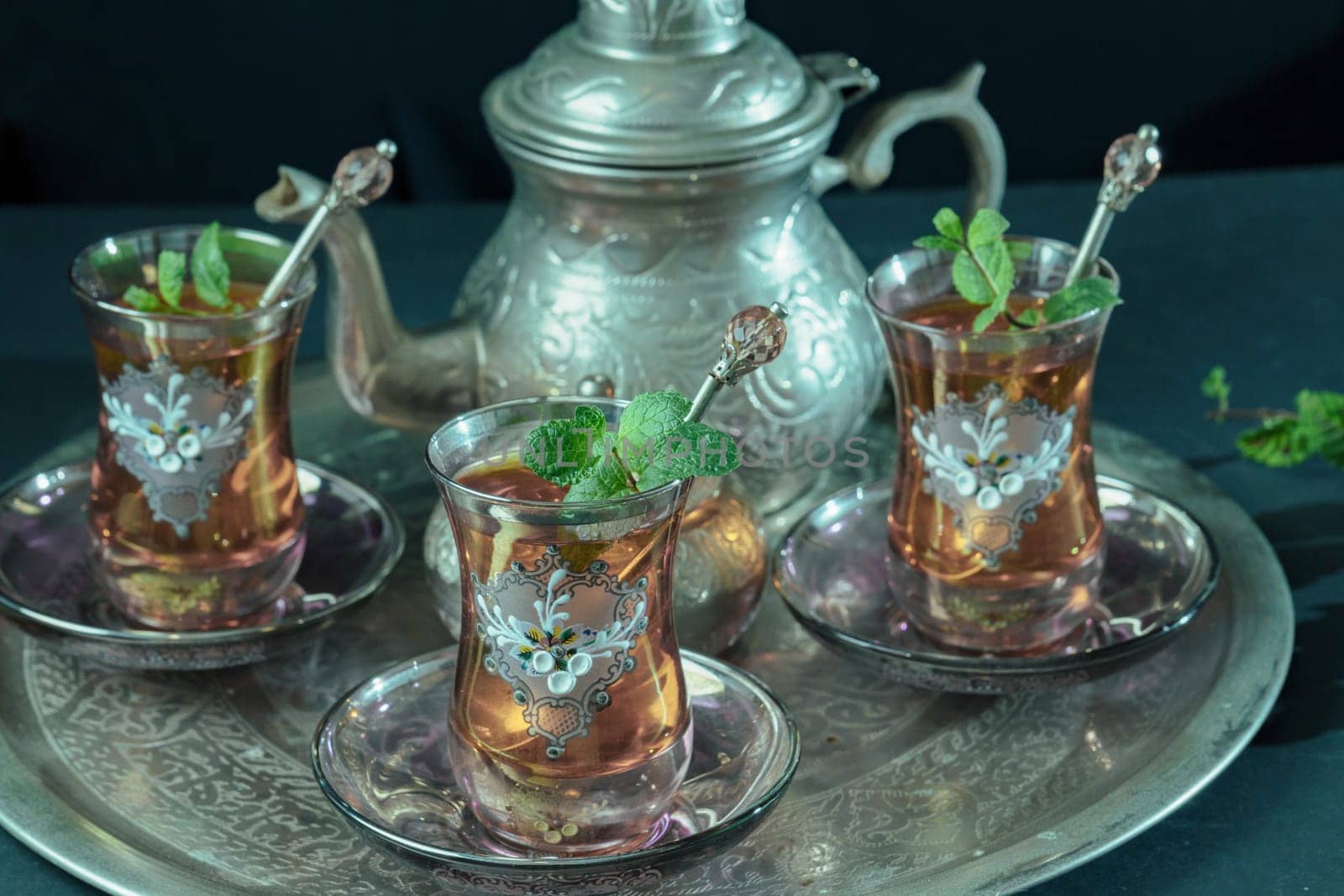 traditional Moorish mint tea service on a tray with decorated glass by joseantona