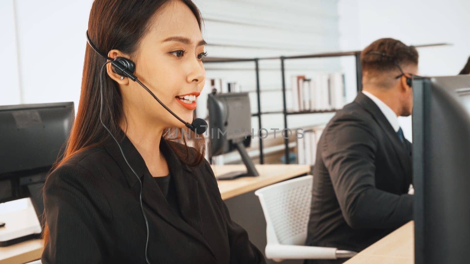 Business people wearing headset working in office to support remote customer or colleague. Call center, telemarketing, customer support agent provide service on telephone video conference call. Jivy