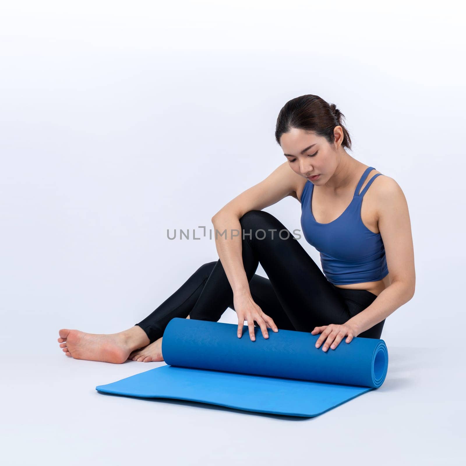 Young attractive asian woman portrait in sportswear with exercising mat. Healthy exercise and workout routine lifestyle concept. Studio shot isolated background. Vigorous