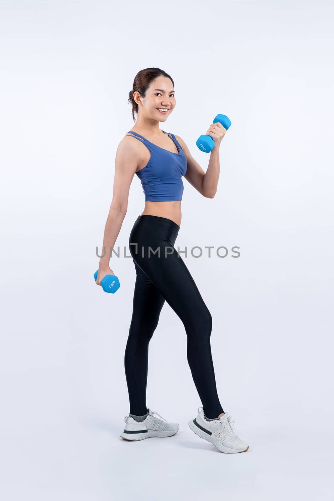 Vigorous energetic woman doing yoga with dumbbell weight exercise. by biancoblue