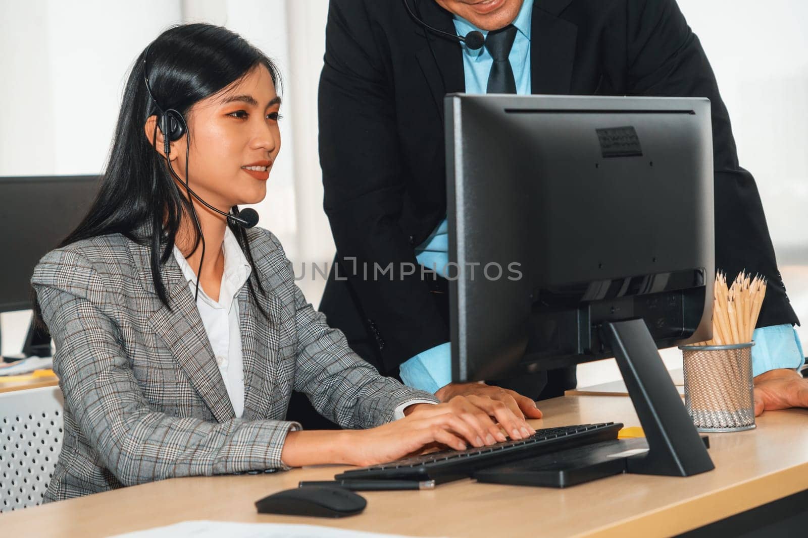 Business people wearing headset working in office to support remote customer or colleague. Call center, telemarketing, customer support agent provide service on telephone video conference call. Jivy