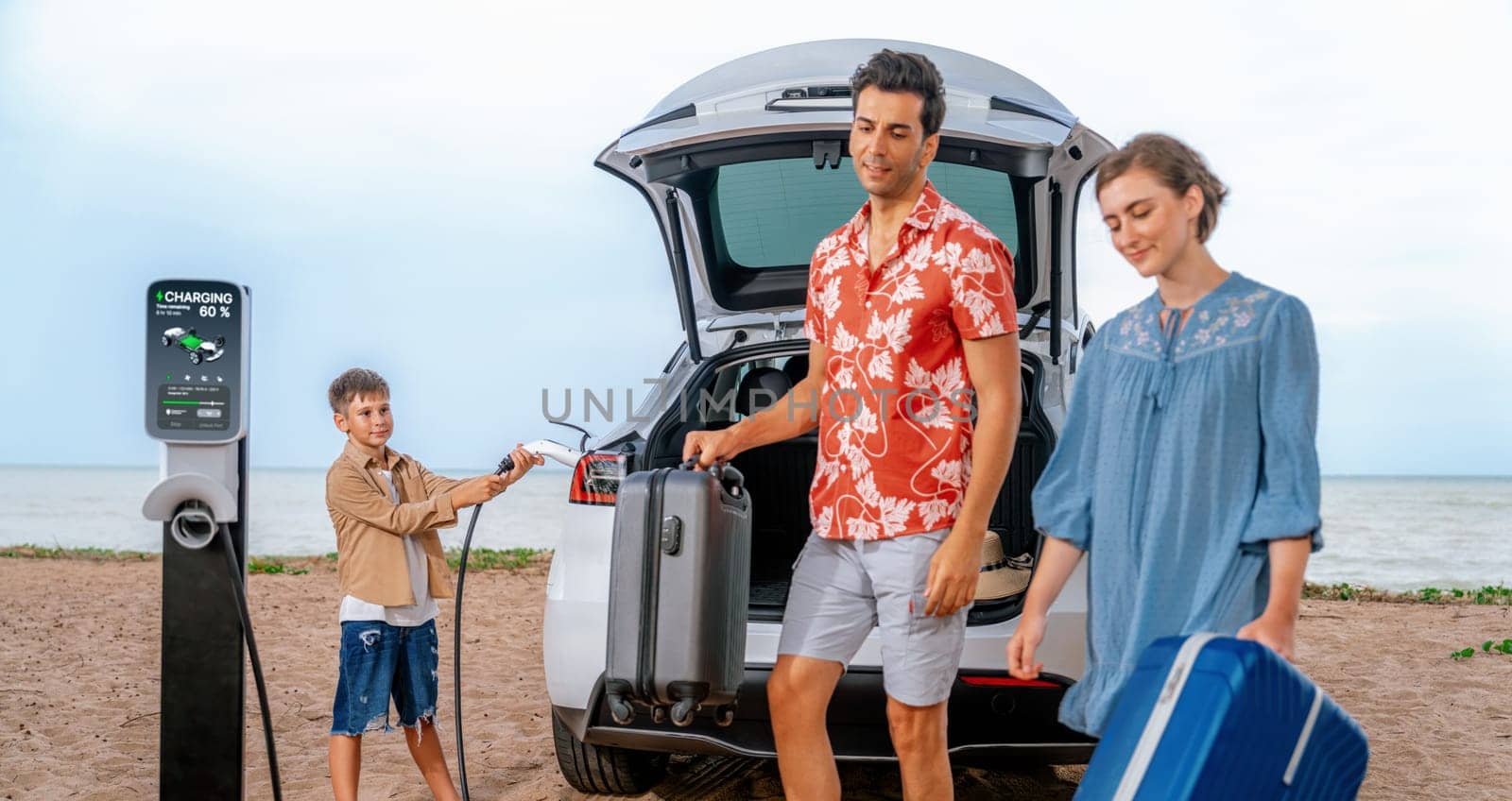 Family vacation trip traveling by the beach with electric car, lovely family taking luggage out while charging EV car battery with clean energy. Alternative family travel by eco-friendly car.Perpetual