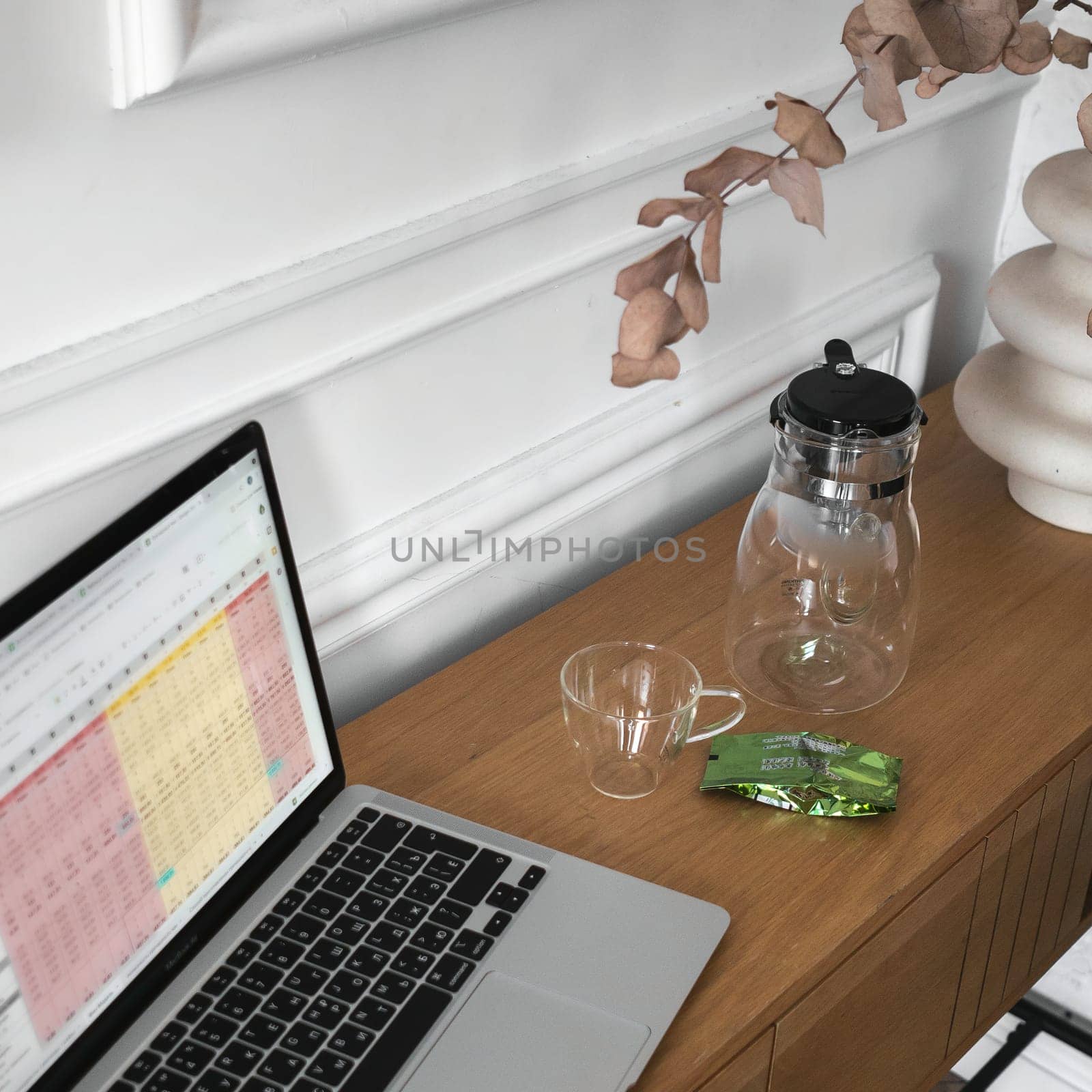 A modern workspace with a sleek laptop, elegant glassware, and vibrant greenery to boost creative productivity