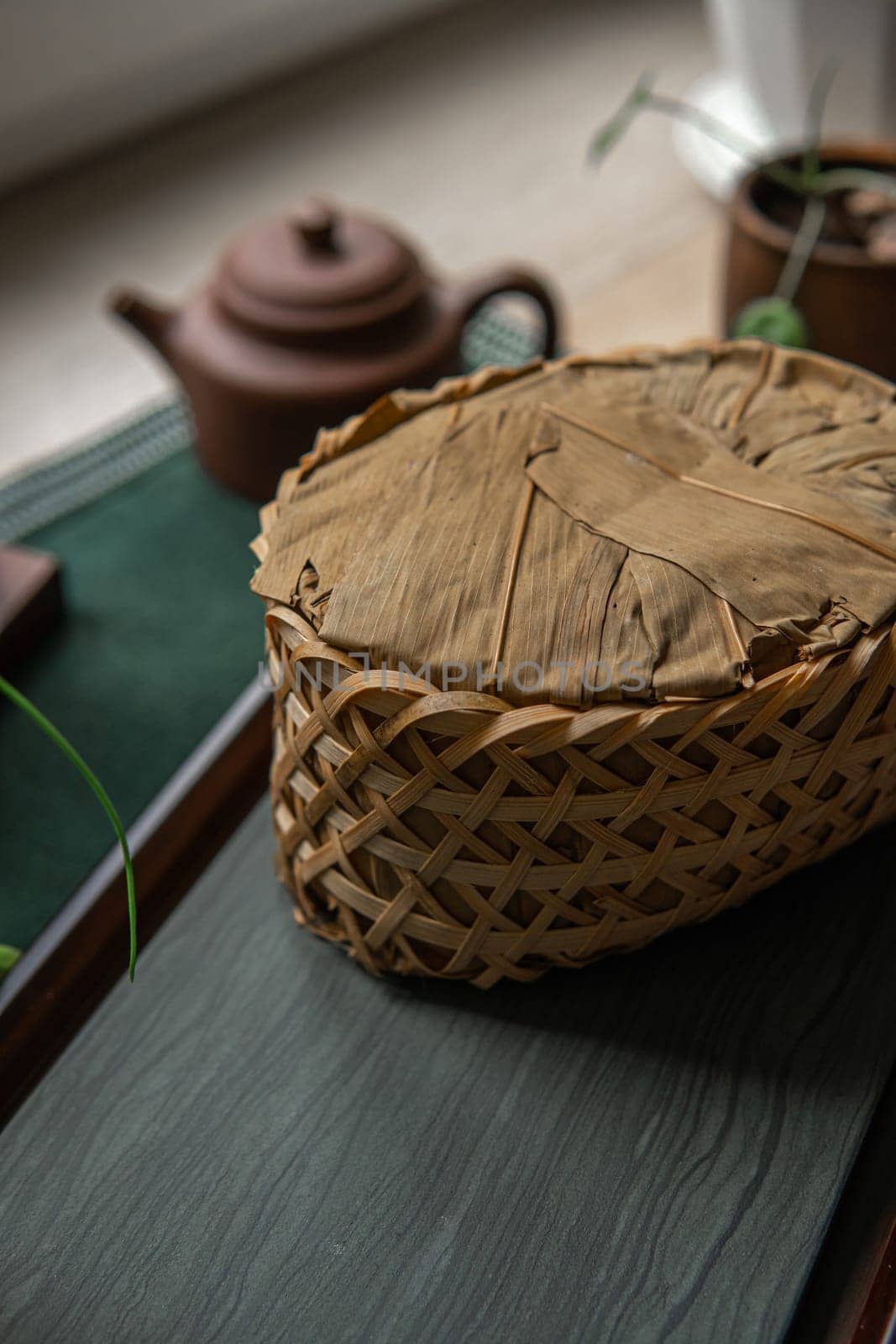 A beautifully woven basket enhances a serene tea setting featuring a charming teapot alongside lovely natural elements