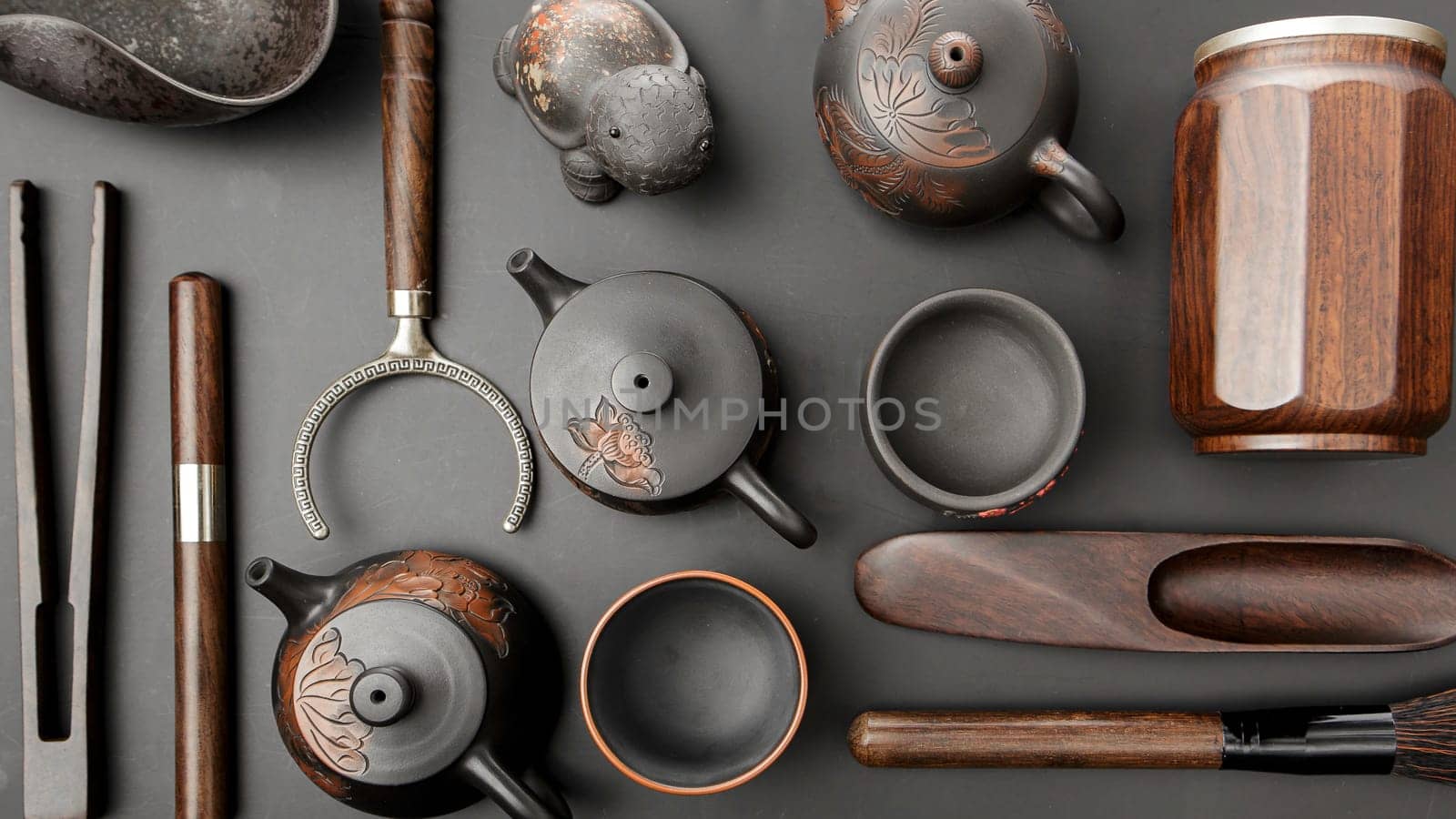 This is an artfully arranged curated collection featuring rustic teapots and various tools displayed aesthetically