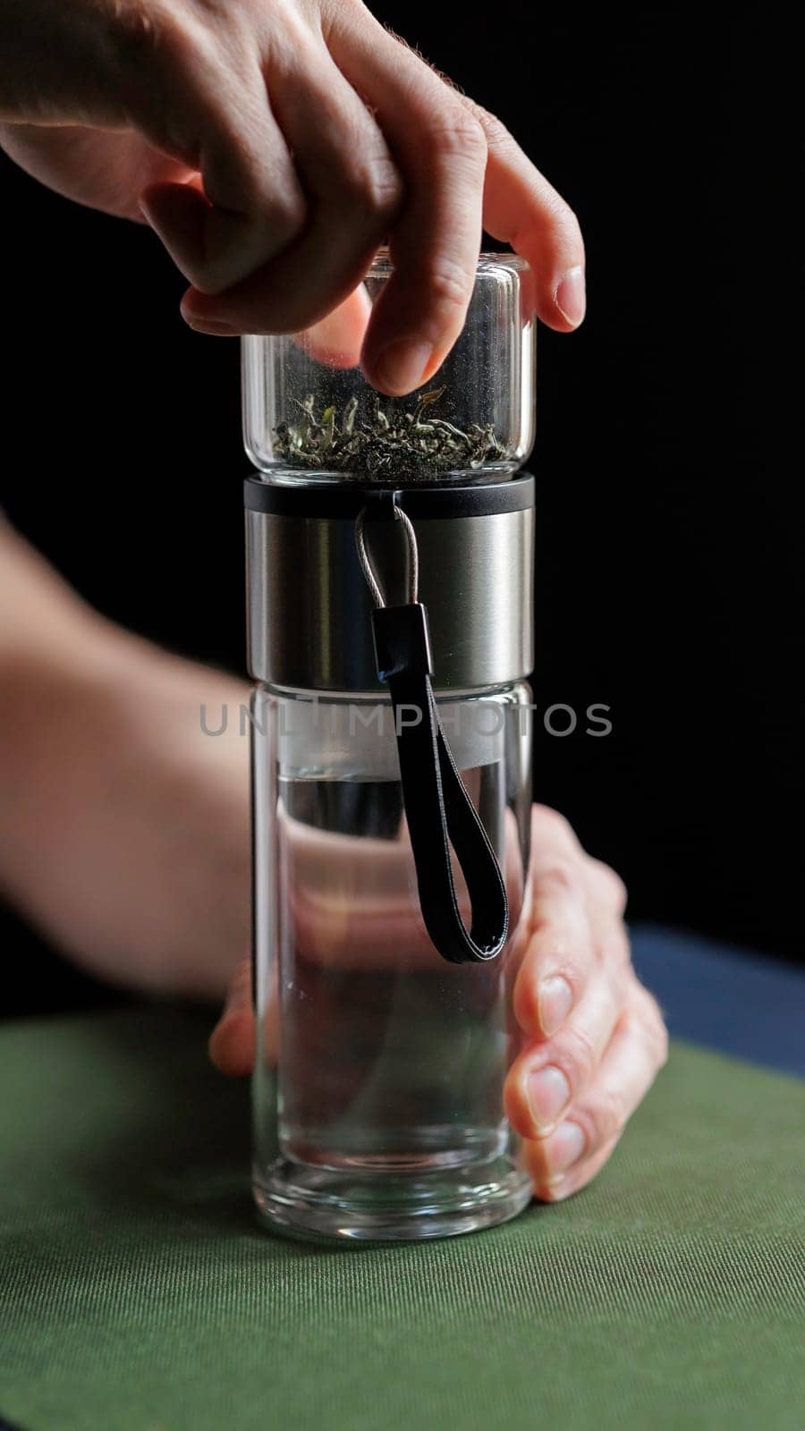A hand skillfully using a modern spice grinder over a glass container, showcasing the art of culinary creativity
