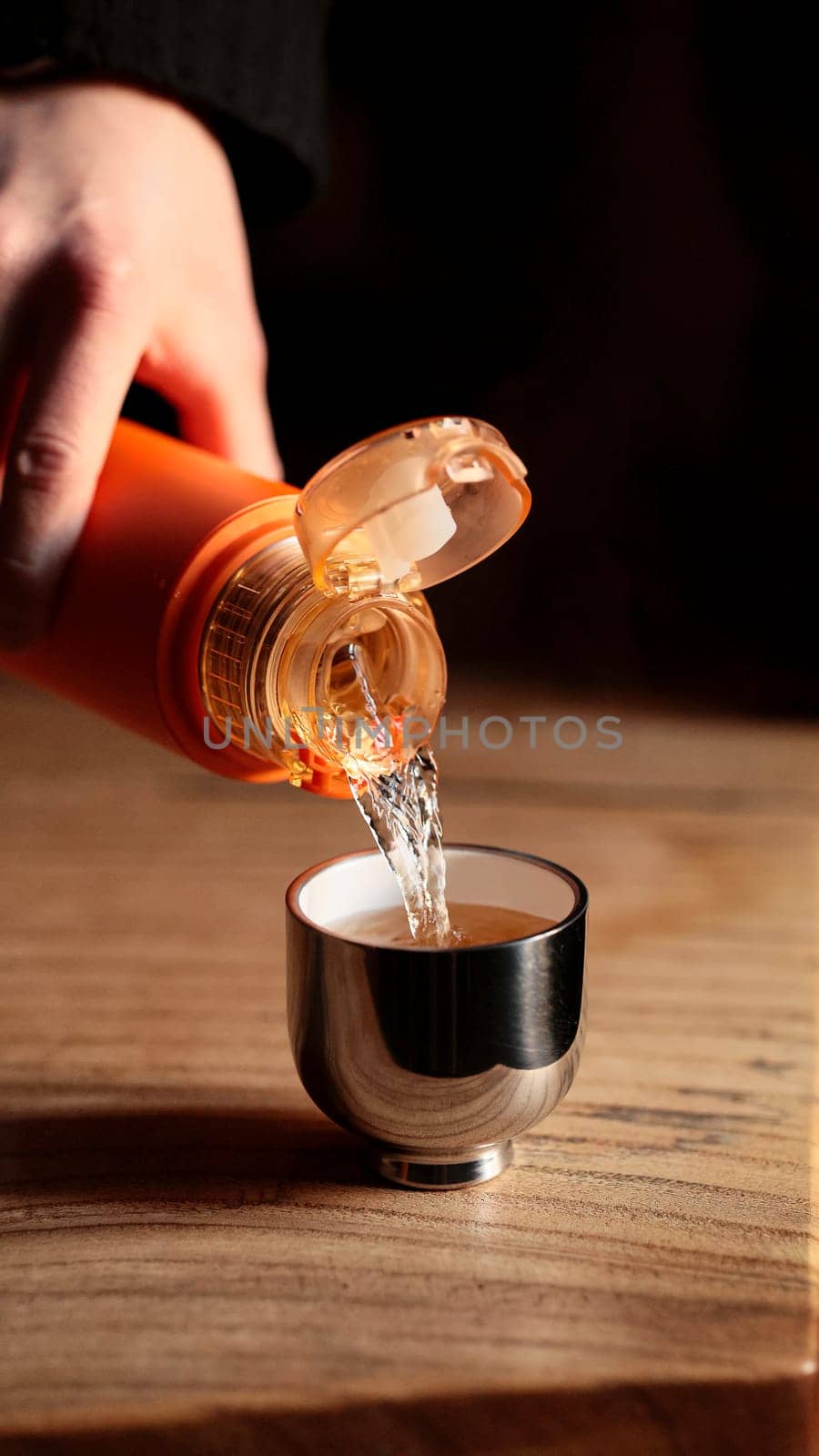 A skilled hand pours a velvety liquid into a shiny shot glass, creating an elegant scene for all to admire