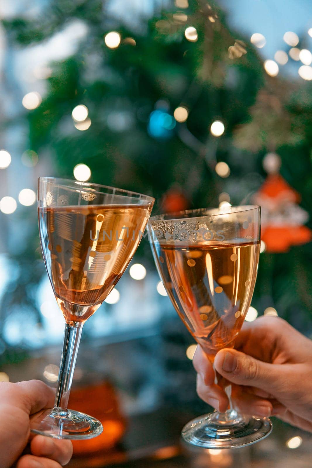 A joyful toast is made with sparkling glasses, surrounded by beautiful festive holiday decorations all around