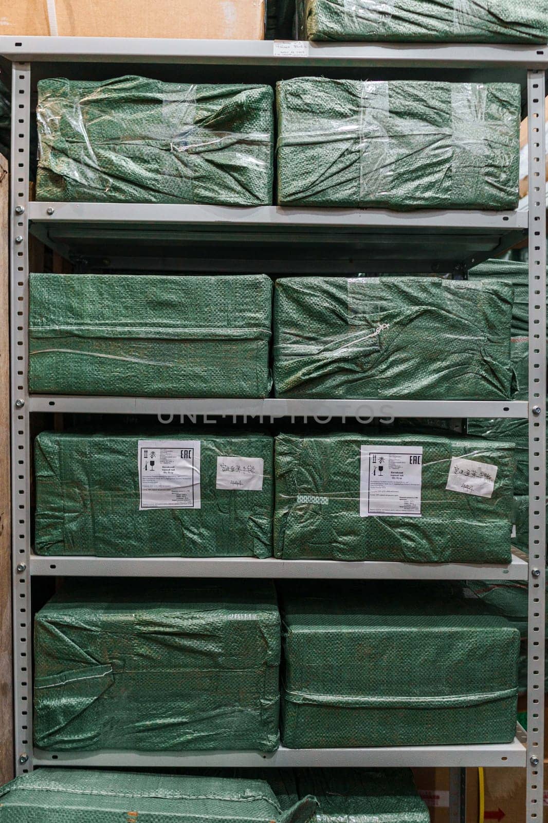 Neatly arranged green boxes on metal shelves, showcasing efficient storage solutions for media items.