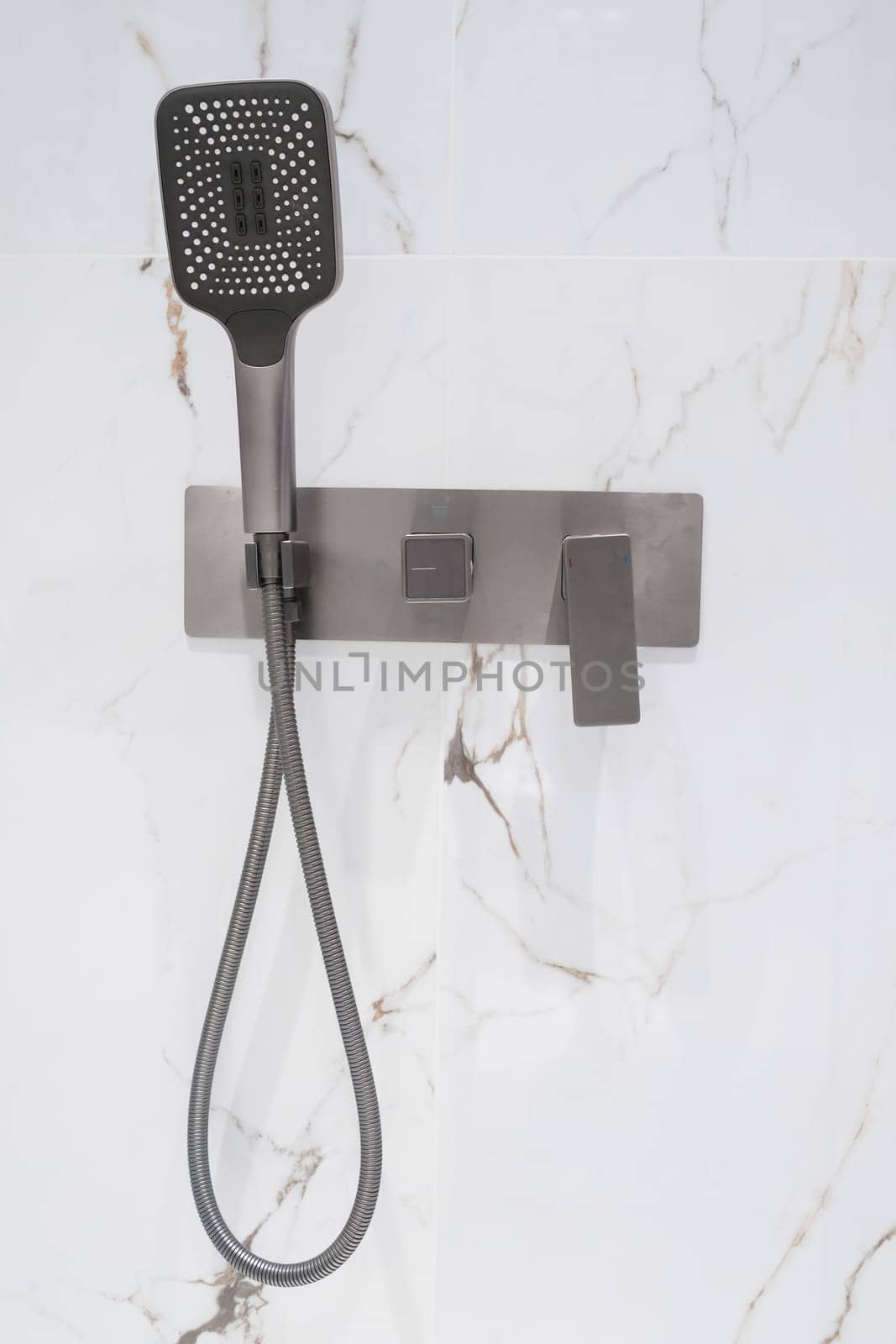 New stylish faucet and shower in shower enclosure with white granite walls. Modern luxury shower cubicle.