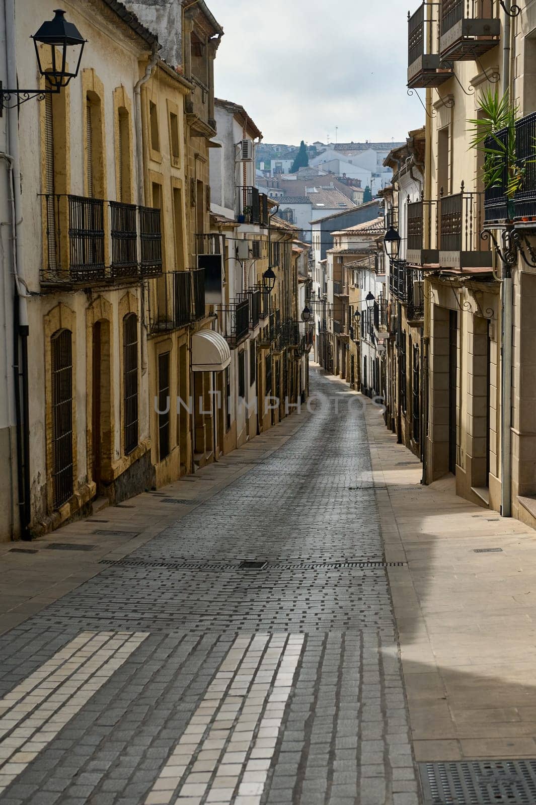 Explore the quaint, narrow street in an old European town, featuring picturesque, historic buildings and charming architecture.