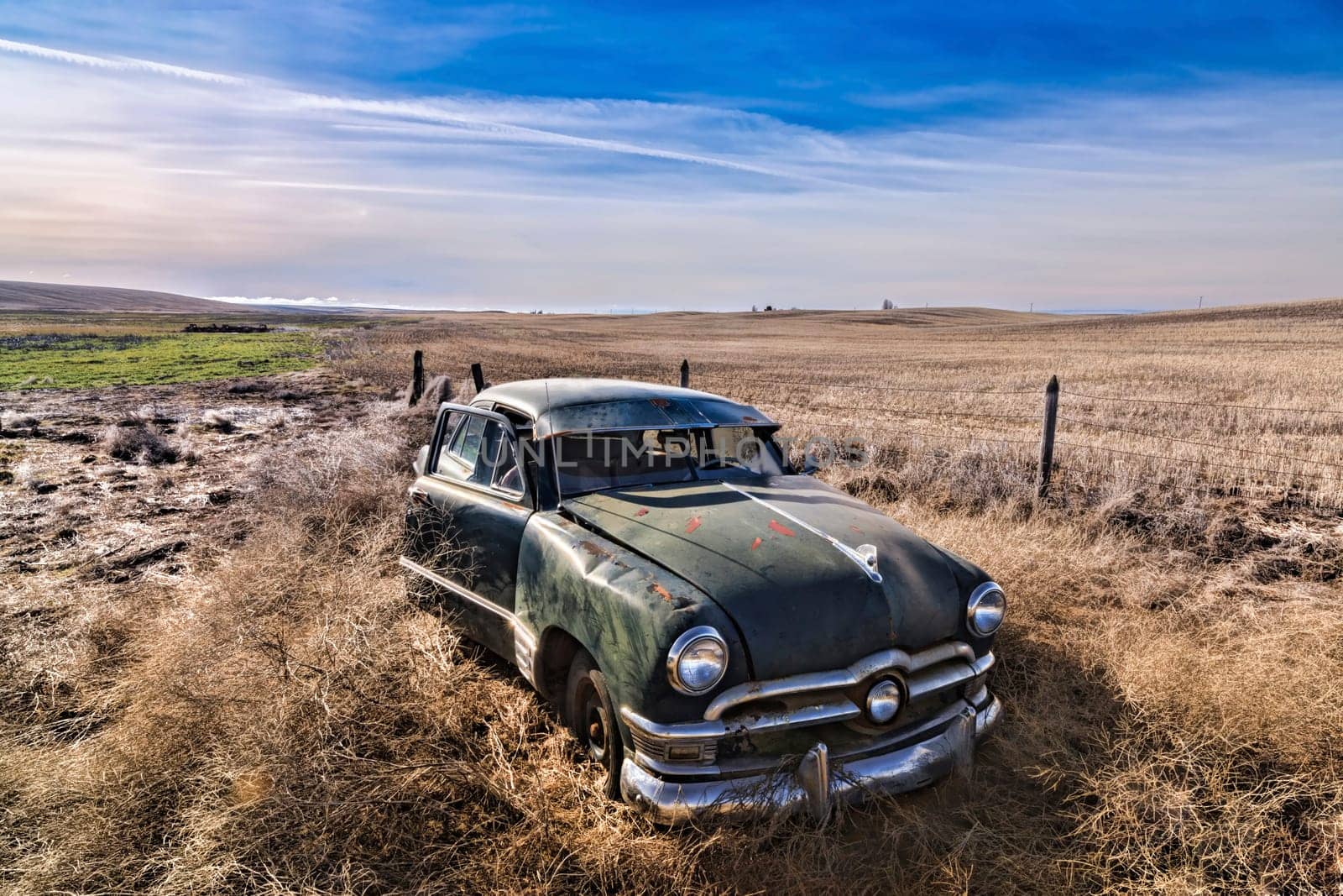 An old abandoned antique car sitting in a field in eastern Washington.