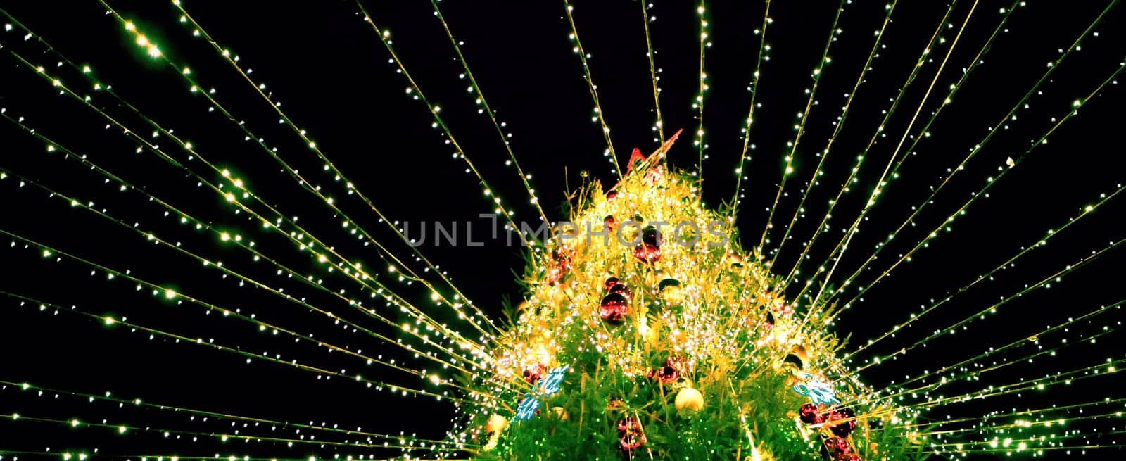 A beautifully decorated Christmas tree covered in colorful ornaments and bright lights radiates joy and warmth during the holiday season.