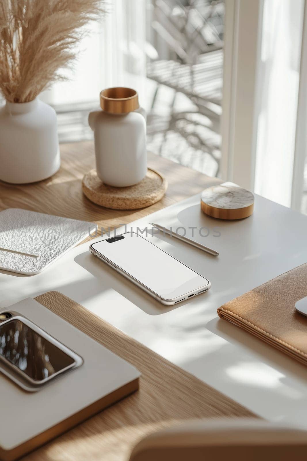 A sleek metallic sticker mockup showcased on a smartphone, placed on a professional desk. the scene includes minimalist tech accessories like headphones, eyeglasses, and a notebook, reflecting contemporary workspace aesthetics.