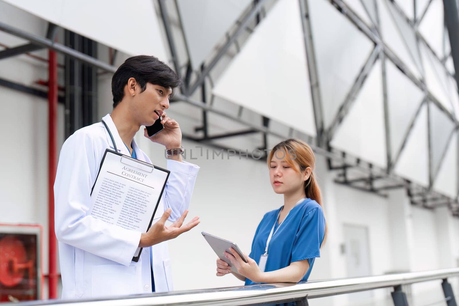 A doctor and nurse engage in a critical discussion about patient care emphasizing teamwork in a hospital environment.