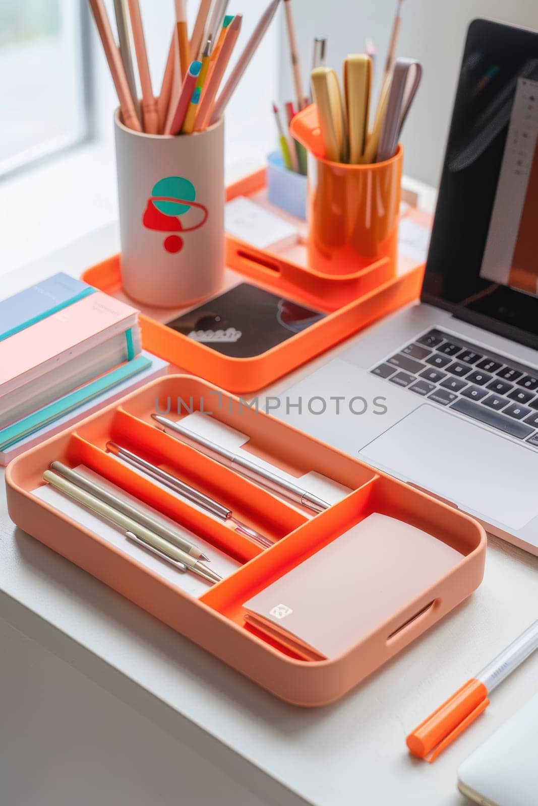 A modern workspace setup featuring mocha mousse file organizers, sleek pens, and a laptop on a bright desk. the stylish arrangement includes a computer, plant, and artistic elements, perfect for inspiring productivity and creativity in a vibrant office setting.