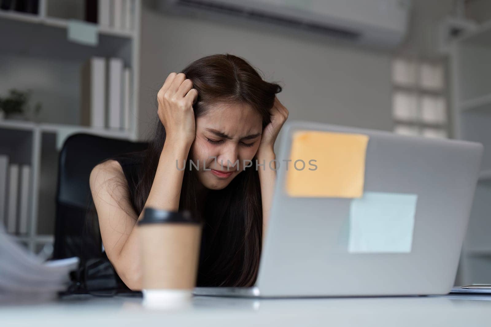 An office worker experiencing stress and frustration at their desk, highlighting workplace pressure and mental health challenges.