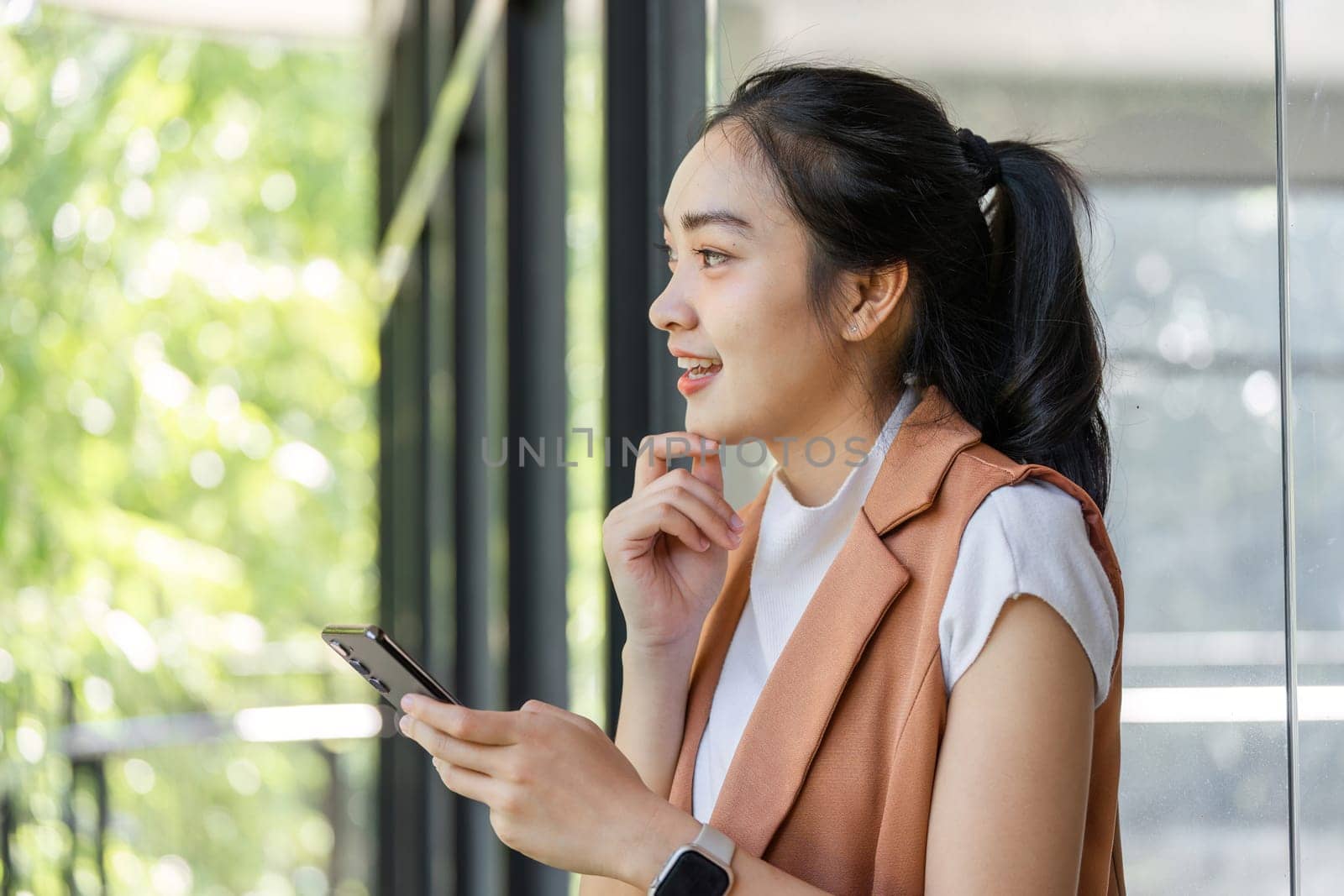Professional woman engaged in stock market analysis using her smartphone, showcasing modern business technology.