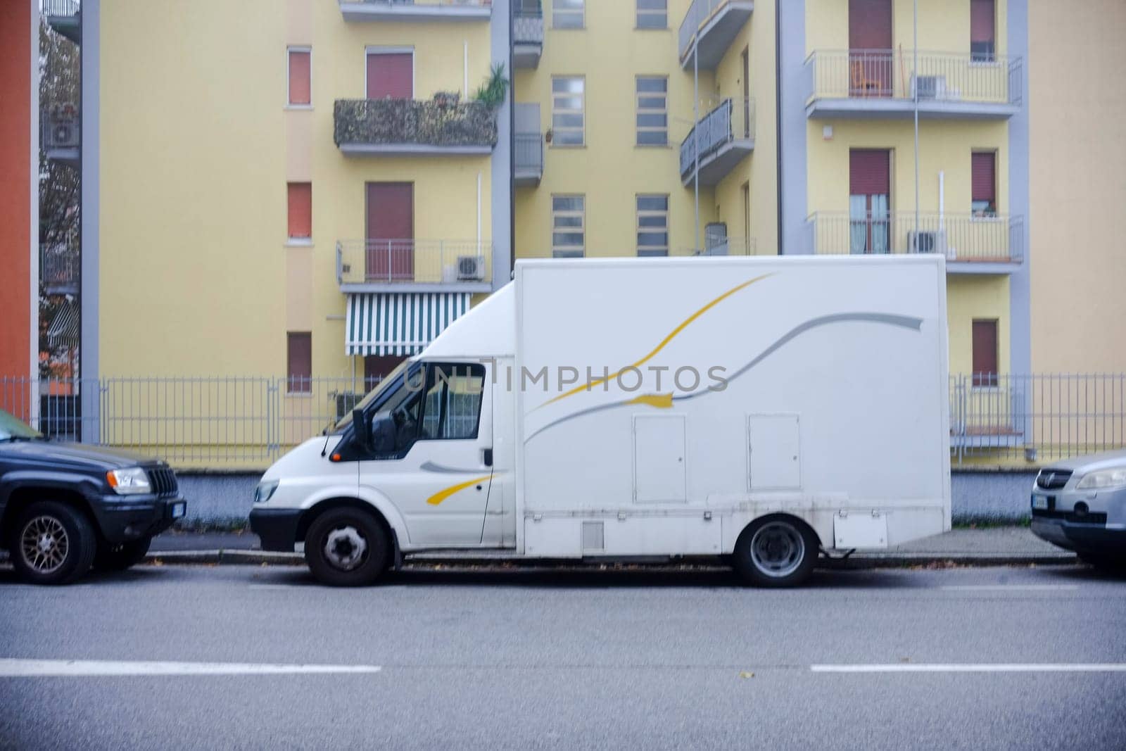 Cremona, Itally - October 6th 2024 White ford transit box truck parked on a residential street, possibly employed for delivery services or small business activities