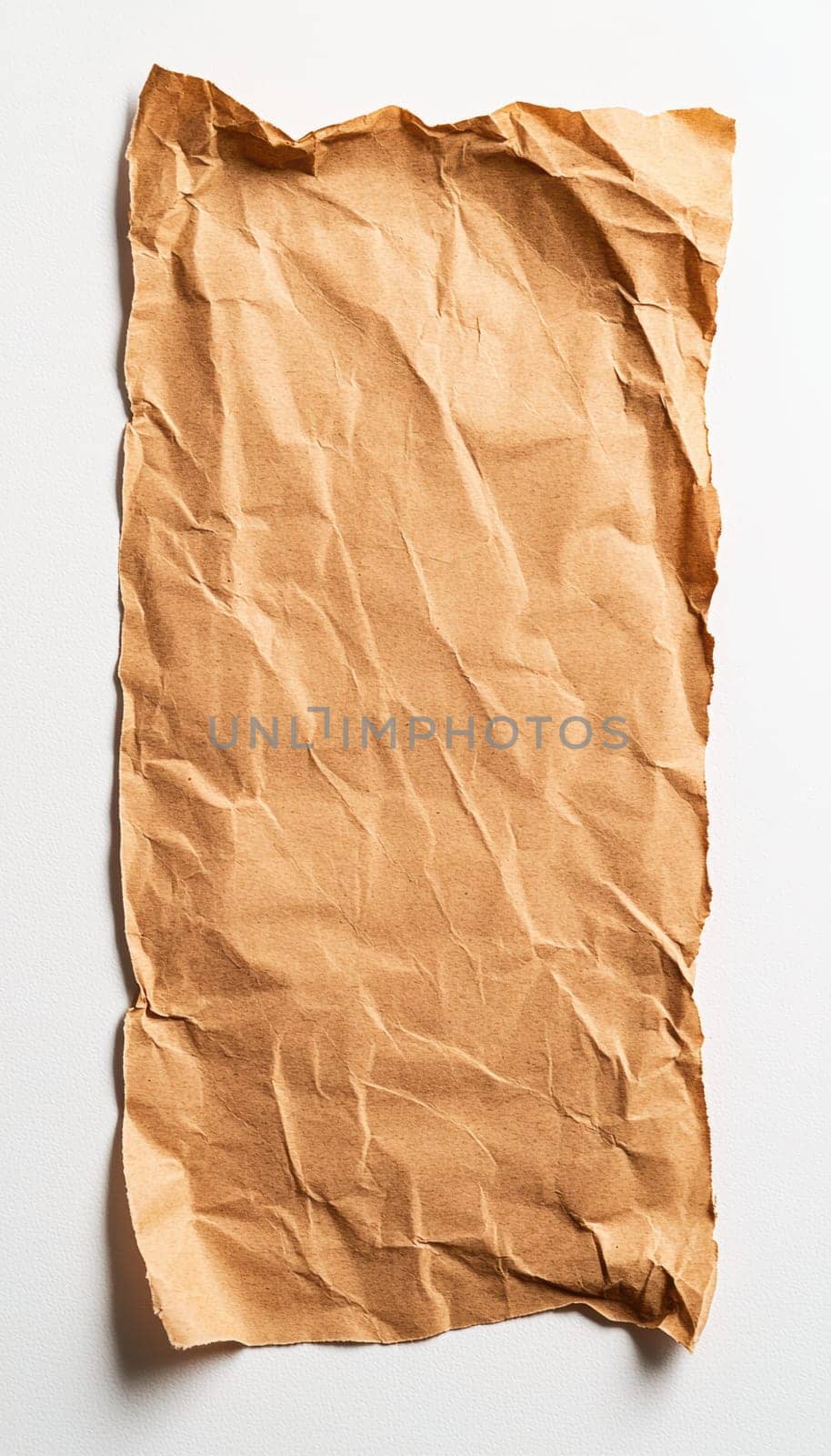 A single piece of torn brown kraft paper is centrally placed on a pristine white background, offering a simple yet effective design ideal for eco-friendly branding, product visuals, or minimalist themed projects.