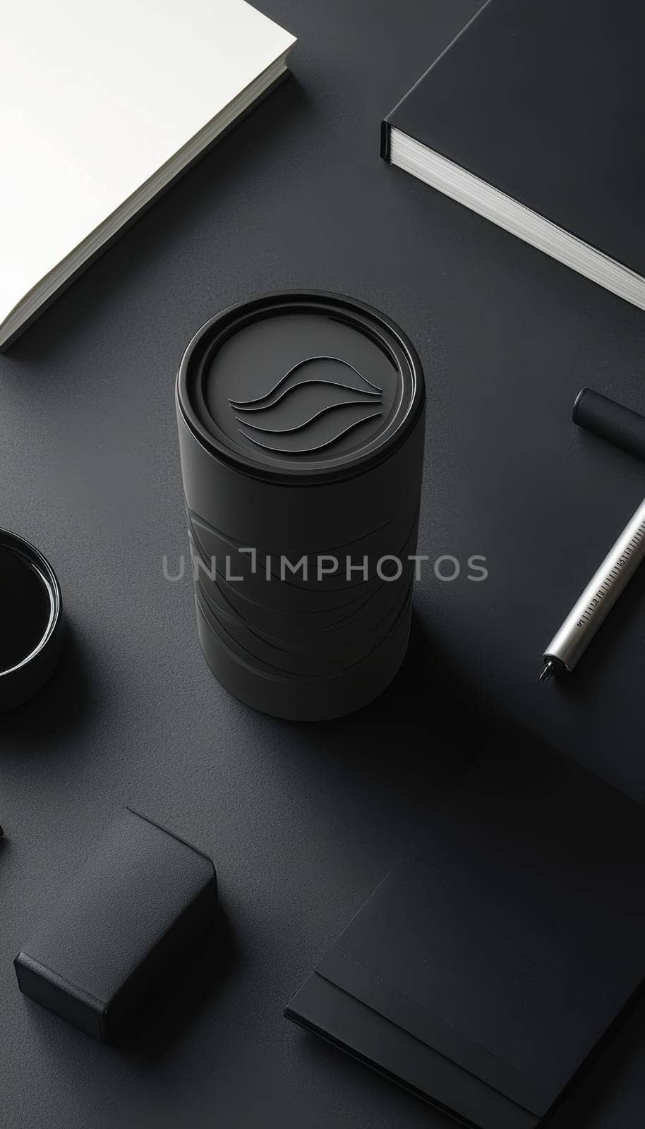 A matte black coffee tumbler adorned with a minimalist circular sticker featuring a clean design. it is surrounded by sophisticated office supplies, creating a harmonious setting with a focus on sleek and modern aesthetics.
