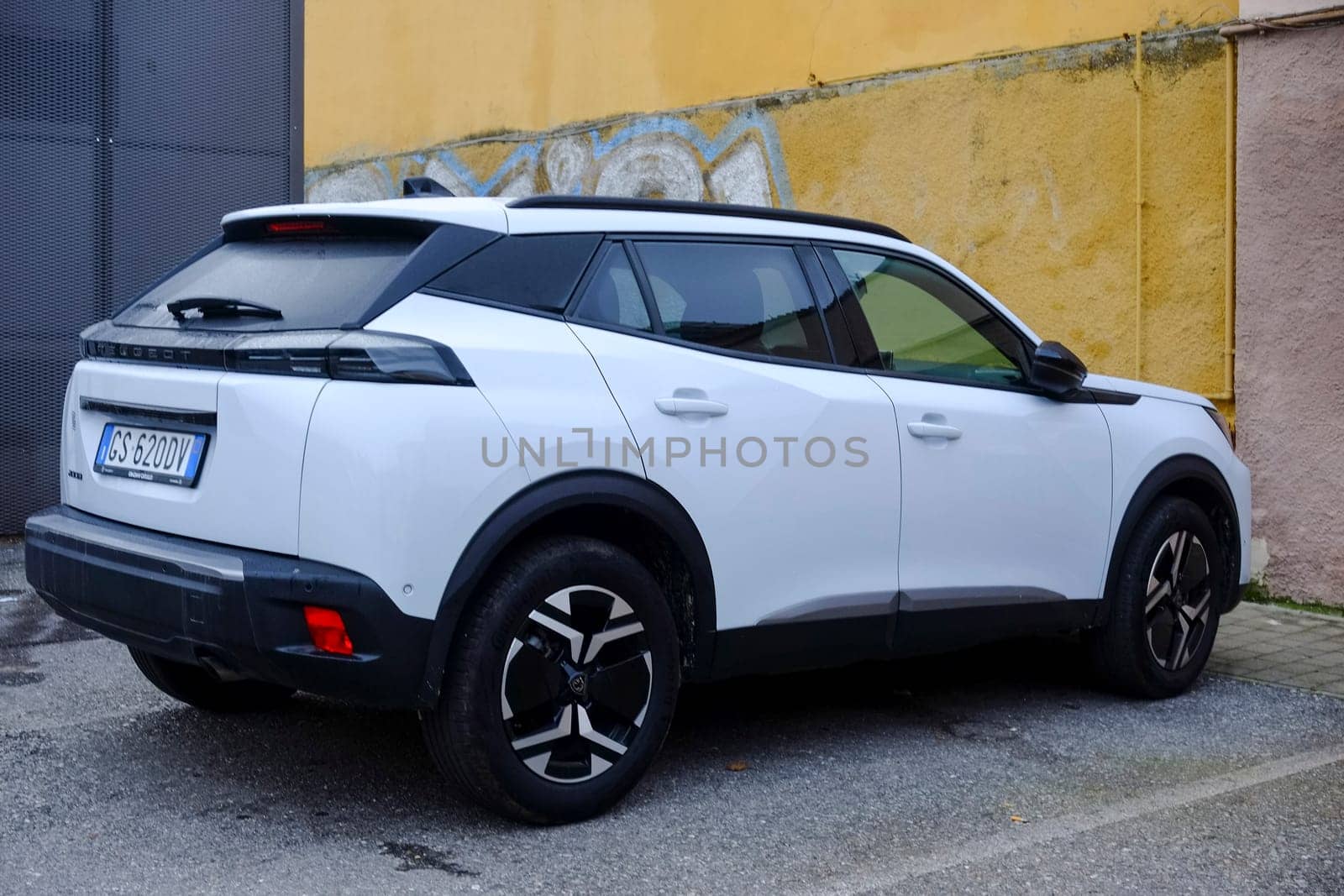 Cremona, Itally - October 6th 2024 Stylish white peugeot 2008 suv with 1.2 puretech 130 hp engine, parked by a yellow wall, highlighting its modern design