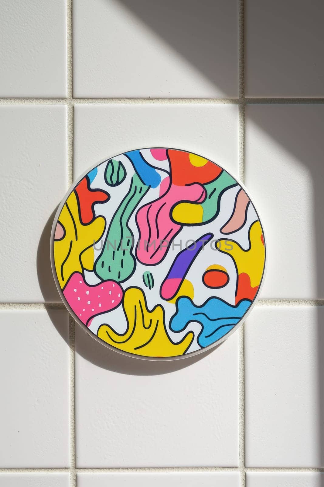 A circular sticker features a vibrant, playful cartoon design, placed on a white ceramic tile. soft lighting enhances the rich colors and intricate details, making it an ideal choice for creative decor or design inspiration.