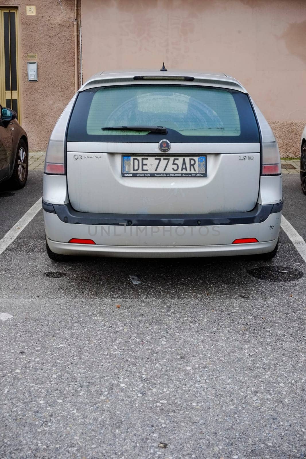 Cremona, Itally - October 6th 2024 Rear view of a silver saab 9-3 sportcombi 1.9 tid parked in a designated parking spot on an asphalt surface, offering a glimpse of urban life