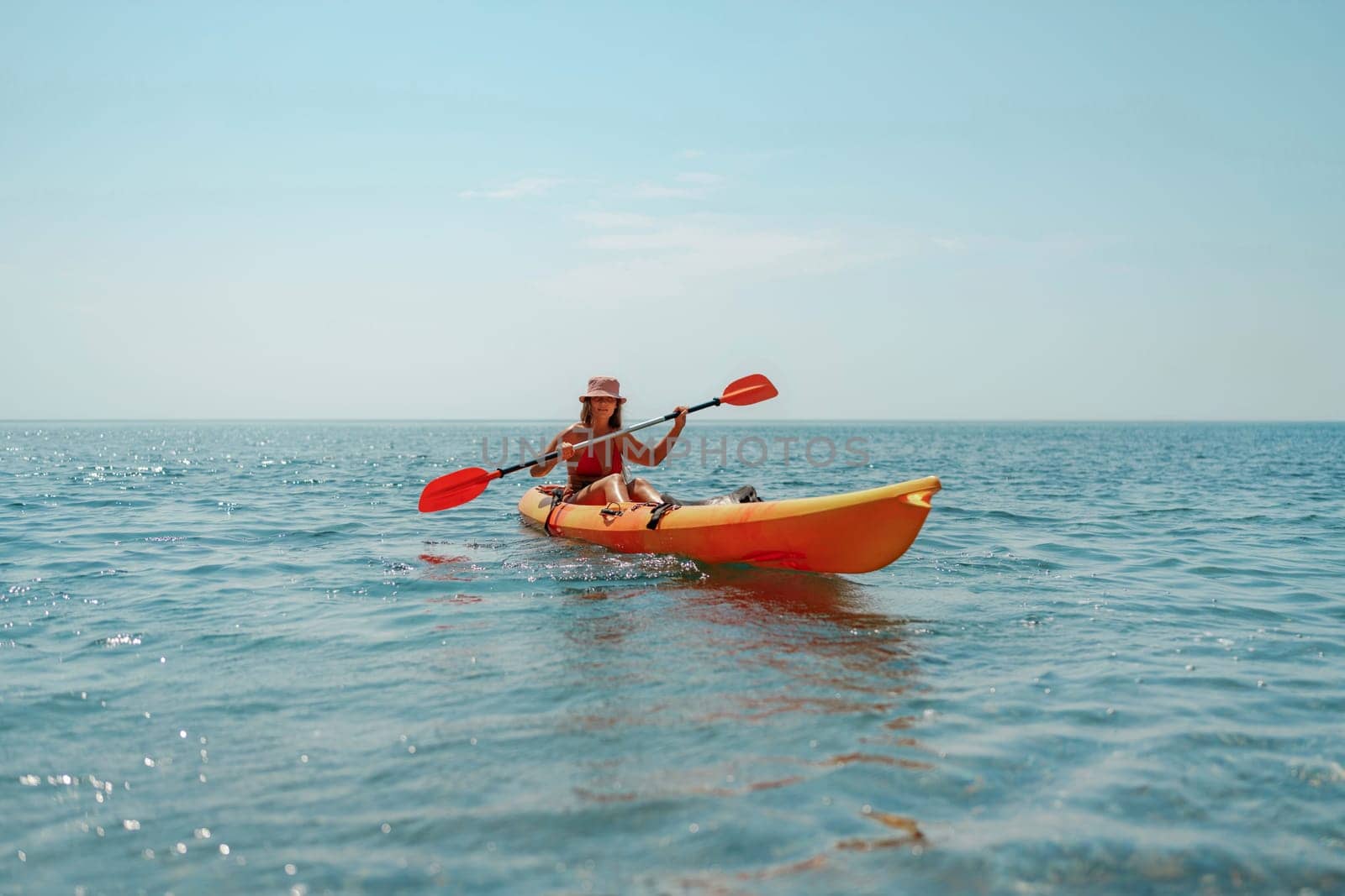 Kayak sea woman. Happy attractive woman with long hair in red swimsuit, swimming on kayak. Summer holiday vacation and travel concept