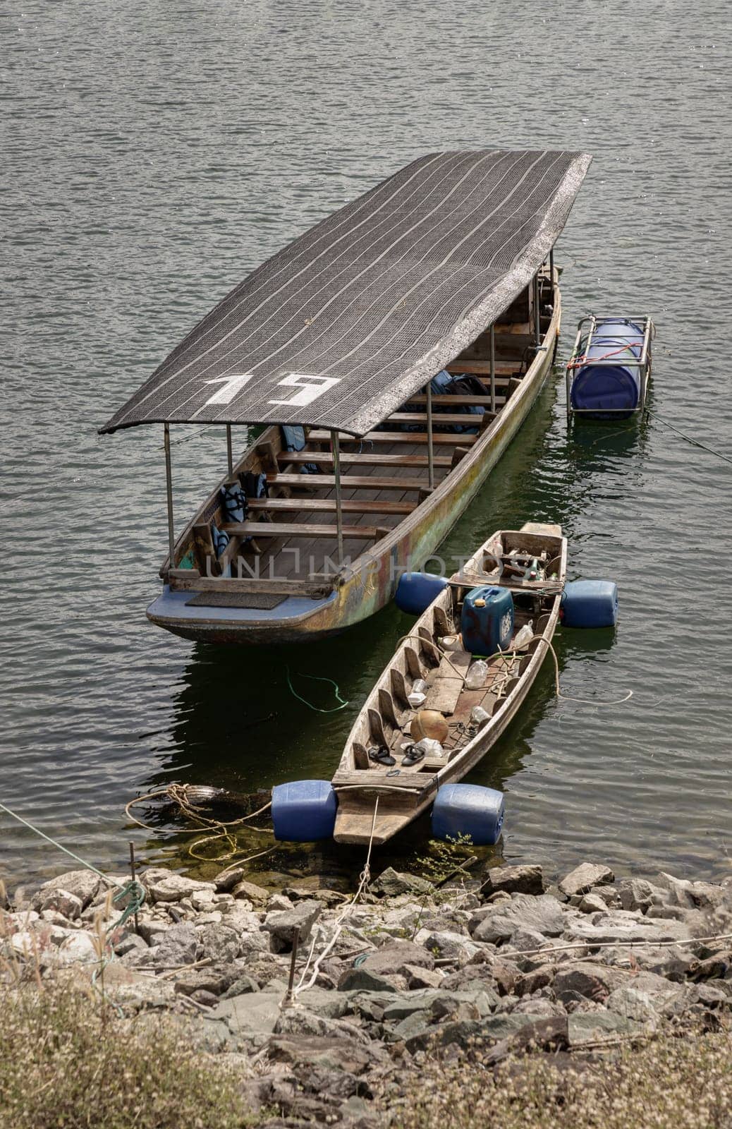 Wooden ferry boat and Traditional hand built small wooden rowboat slowly was resting along in the dam.Transportation by boat, use it as your Wallpaper, Poster and Space for text, Selective focus.