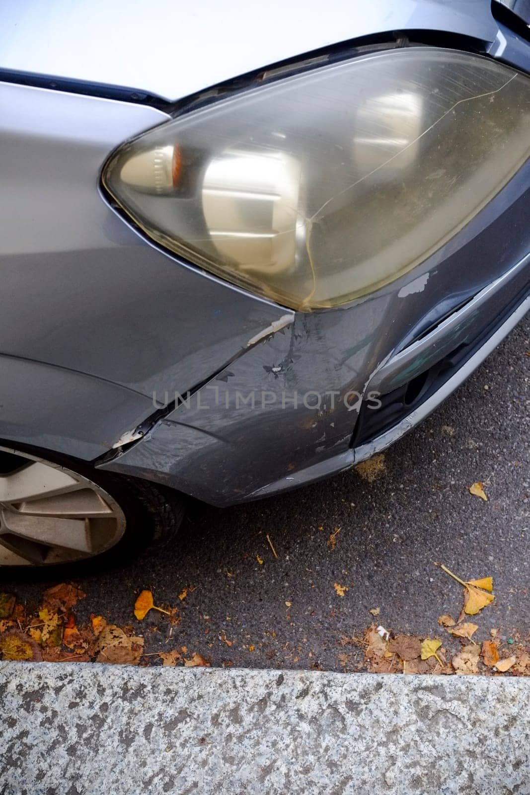Cremona, Itally - October 6th 2024 Close-up photo of a silver opel corsa c parked on the street, showcasing the impact and scratches on the damaged bumper and headlight