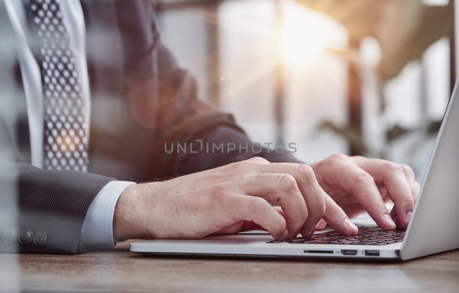 Person typing on laptop keyboard, businessman working on laptop