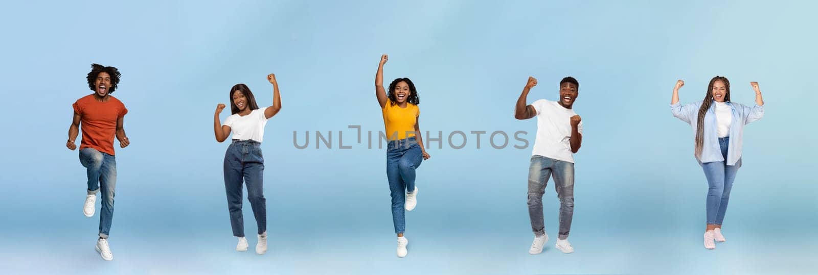 Smiling black young people jumping, making success sign, celebrating victory, enjoy spare time, have fun, isolated on blue studio background, panorama. Winners, free time and lifestyle