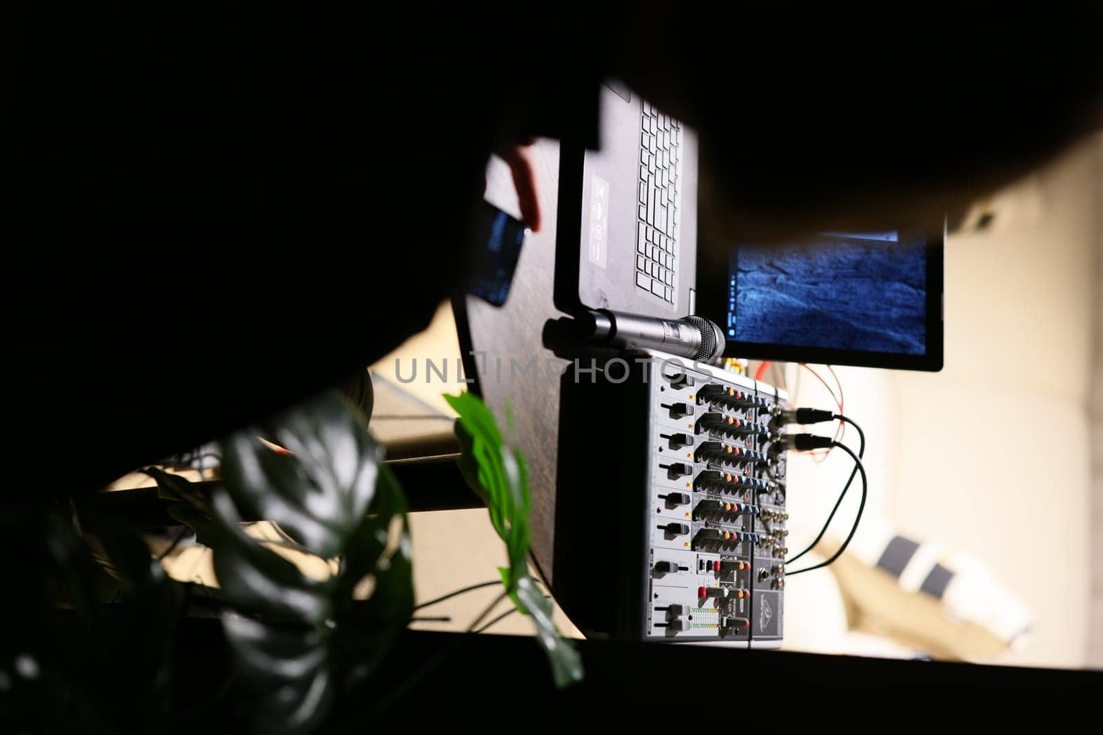 This is a focused view showcasing an audio mixer paired with a laptop setup, ideal for media production environments