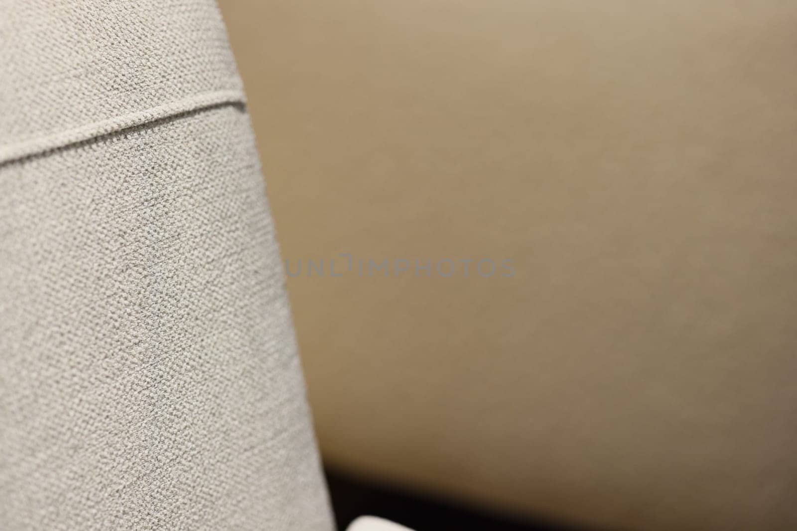 A closeup view of stylish fabric covering contemporary furniture, highlighting its graceful neutral hues