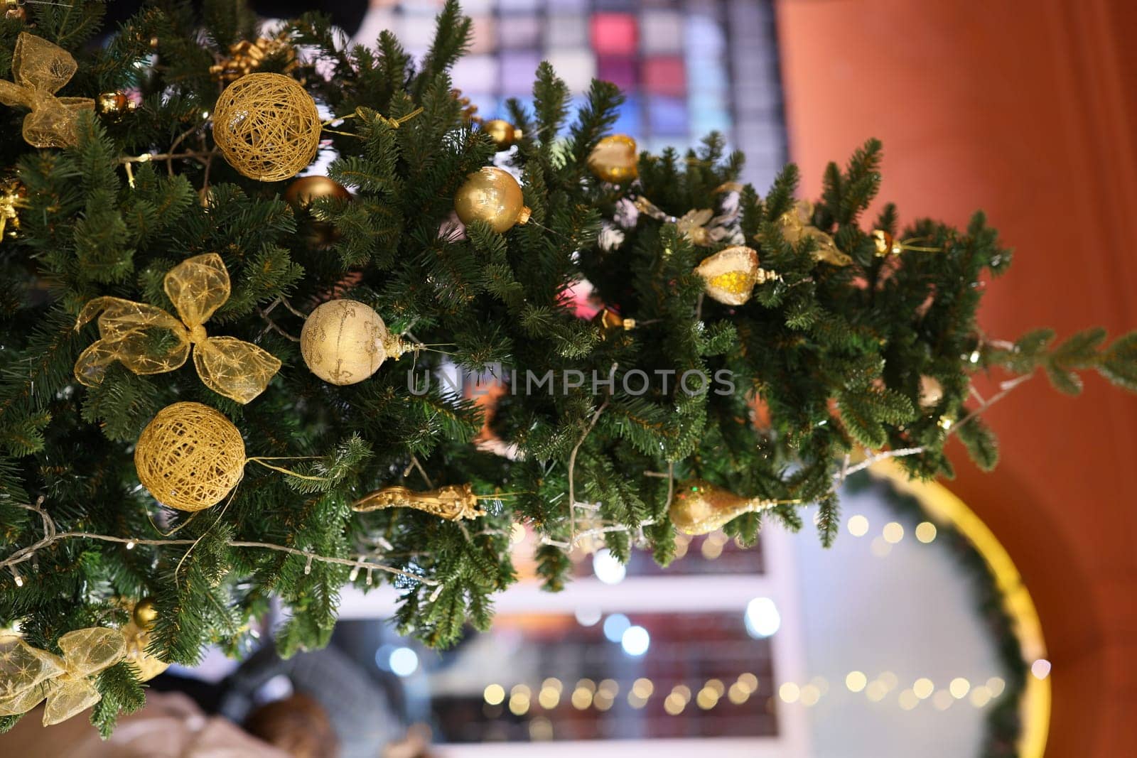 A beautifully decorated Christmas tree, lavishly adorned with shimmering gold ornaments and vibrant festive ribbons